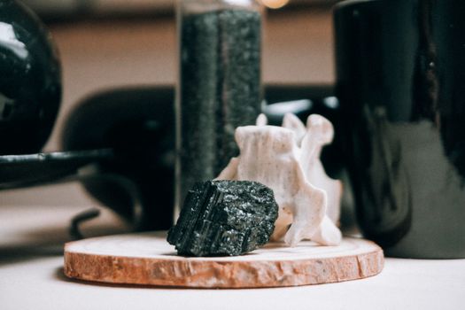 Wooden round shaped board with textured black stone on blurred background of magic interior
