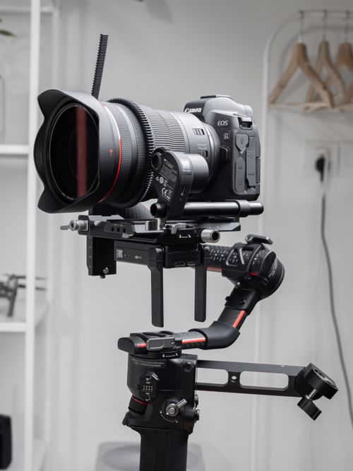 Free Canon EOS camera with lens mounted on a stabilization gimbal indoors. Stock Photo