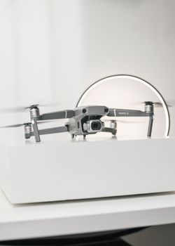 Minimalist close-up of a drone on a white surface with a sleek, modern design.