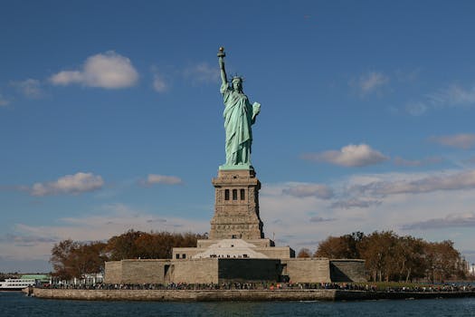 Iconic view of the Statue of Liberty against a blue sky in New York City, USA.