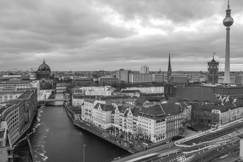 Free A dramatic black and white aerial view of Berlin featuring the iconic Fernsehturm and Spree River. Stock Photo