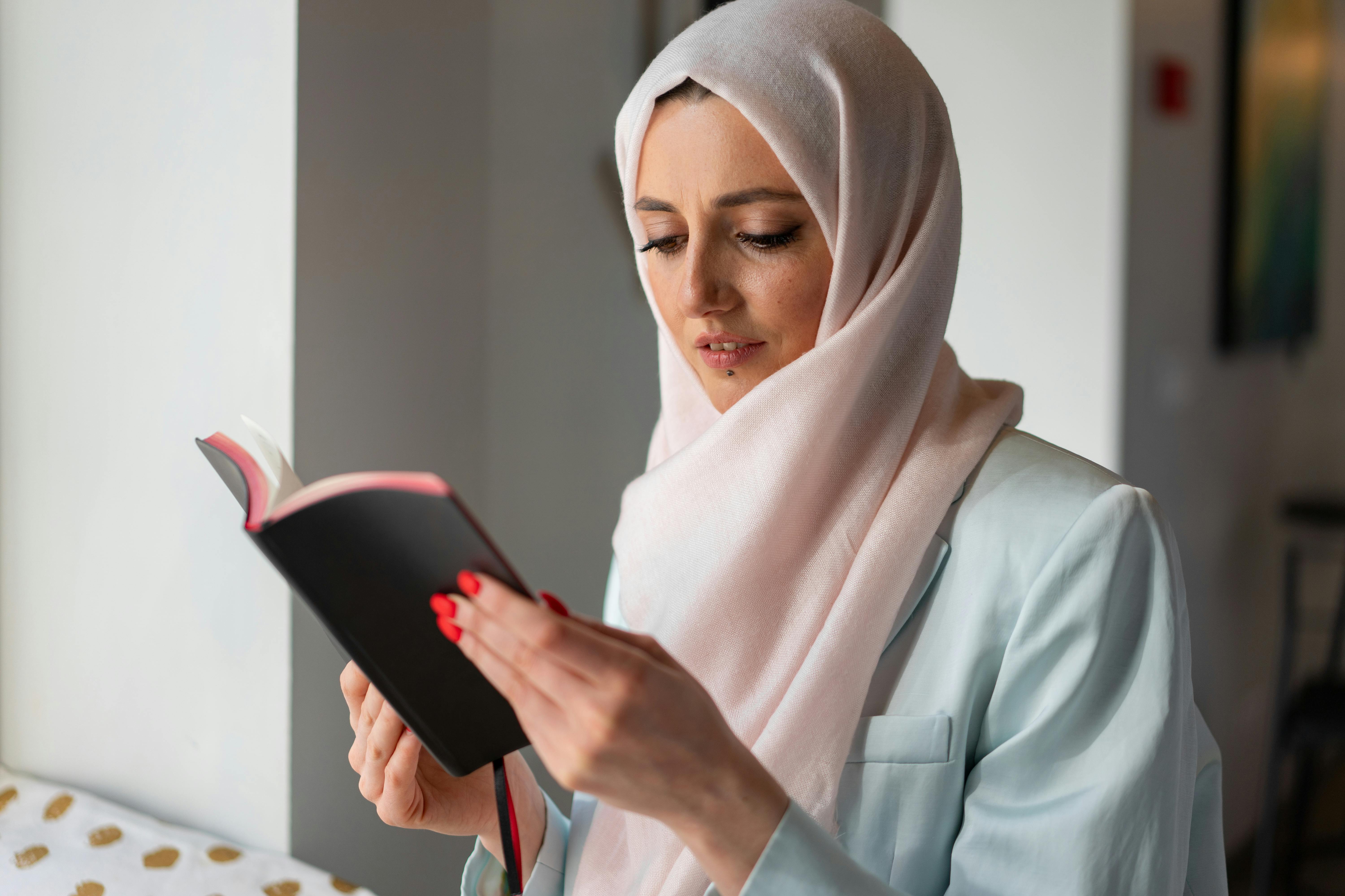 Woman Wearing Hijab Writing on a Notebook · Free Stock Photo