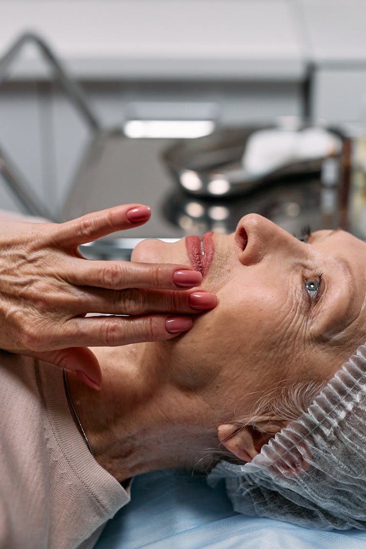 An Elderly Woman Touching Her Face
