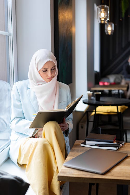 실버 Ipad를 사용하는 흰색 Hijab 여자
