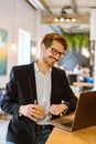 Man in Black Suit Jacket Wearing Black Framed Eyeglasses Holding Clear Drinking Glass