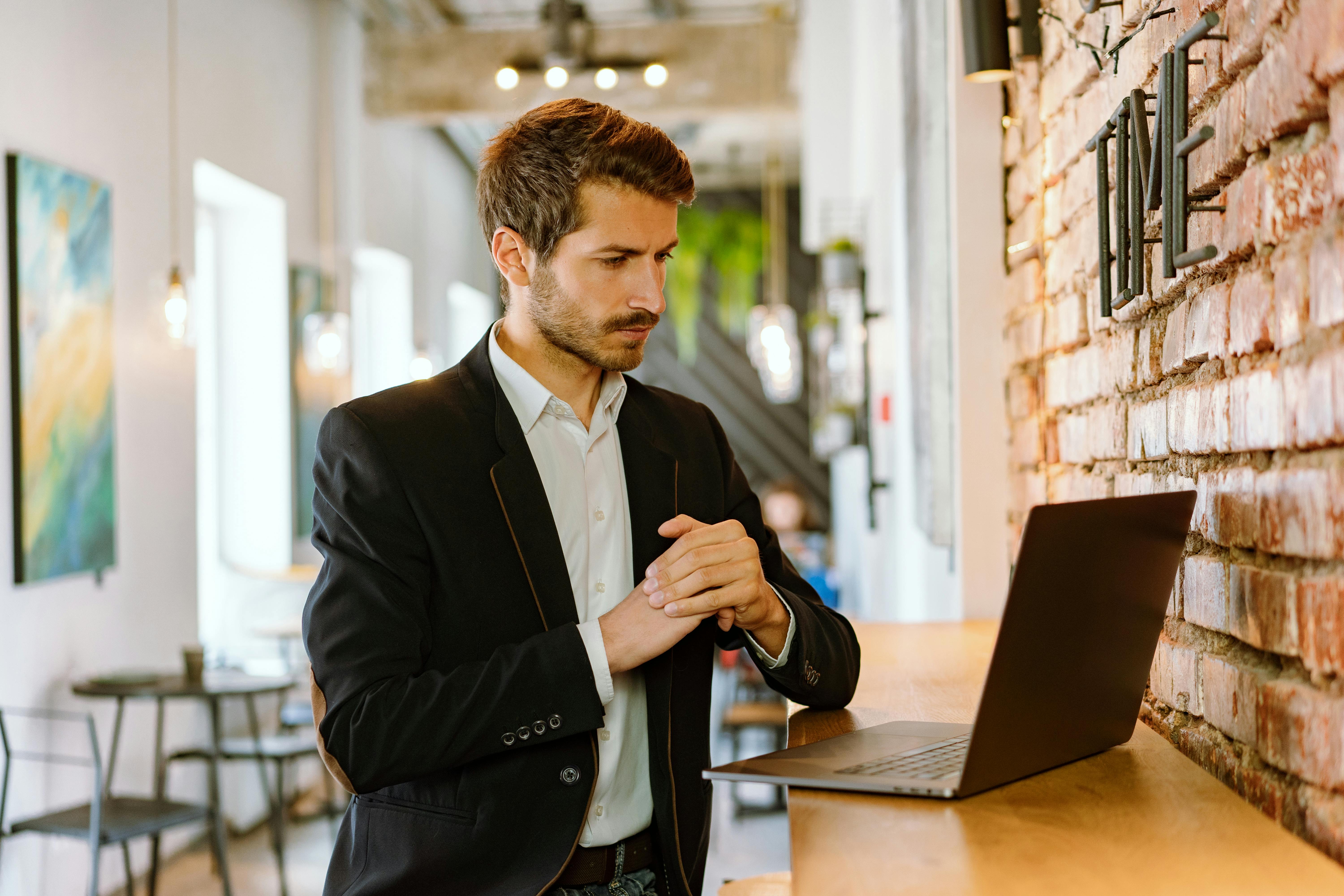 man in black suit jacket using black laptop computer