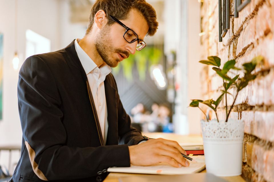 A man writing notes in a café