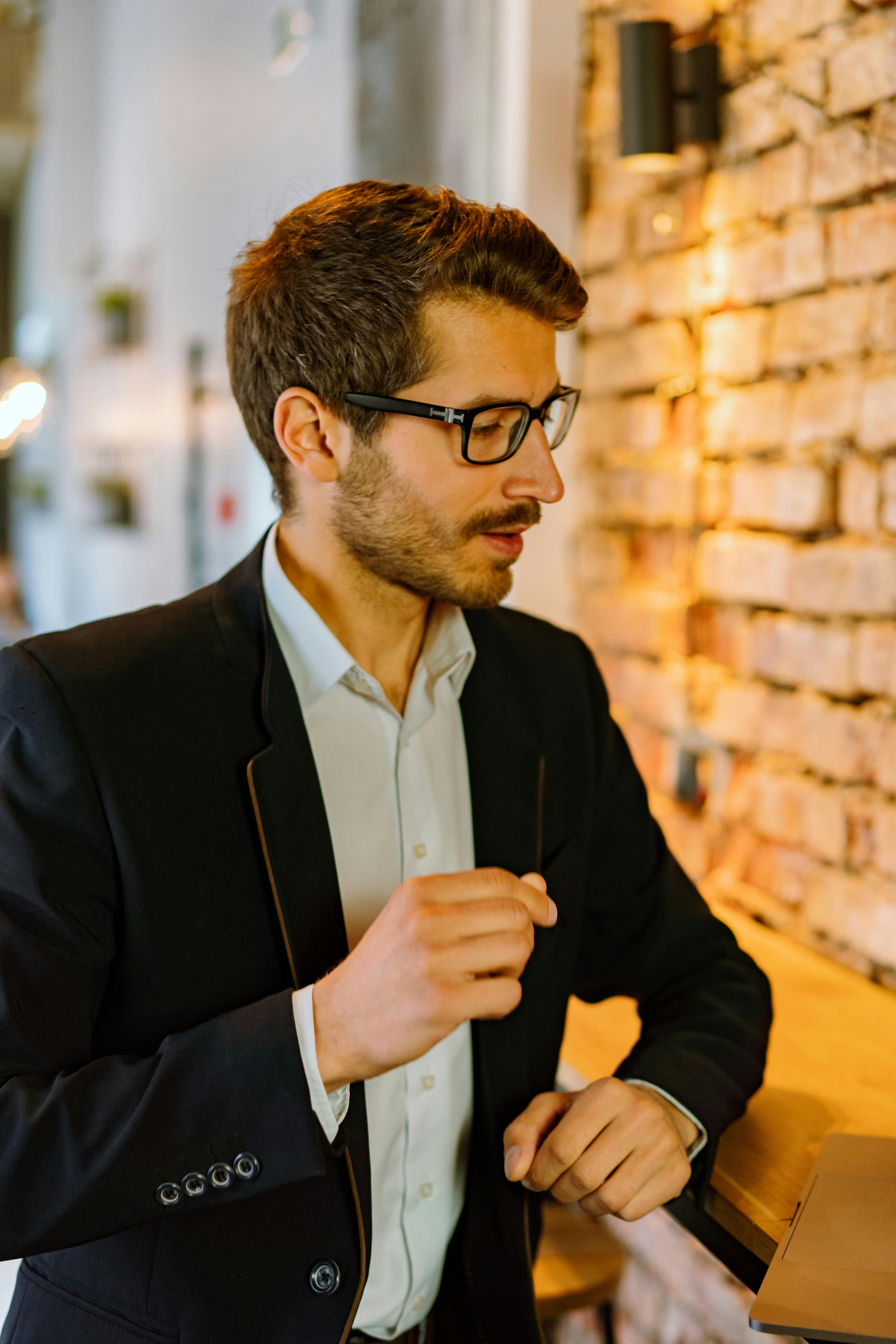 man in black suit jacket wearing eyeglasses