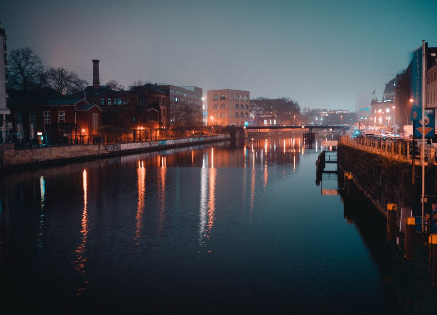 Stunning nighttime view of a Berlin canal reflecting city lights and buildings.
