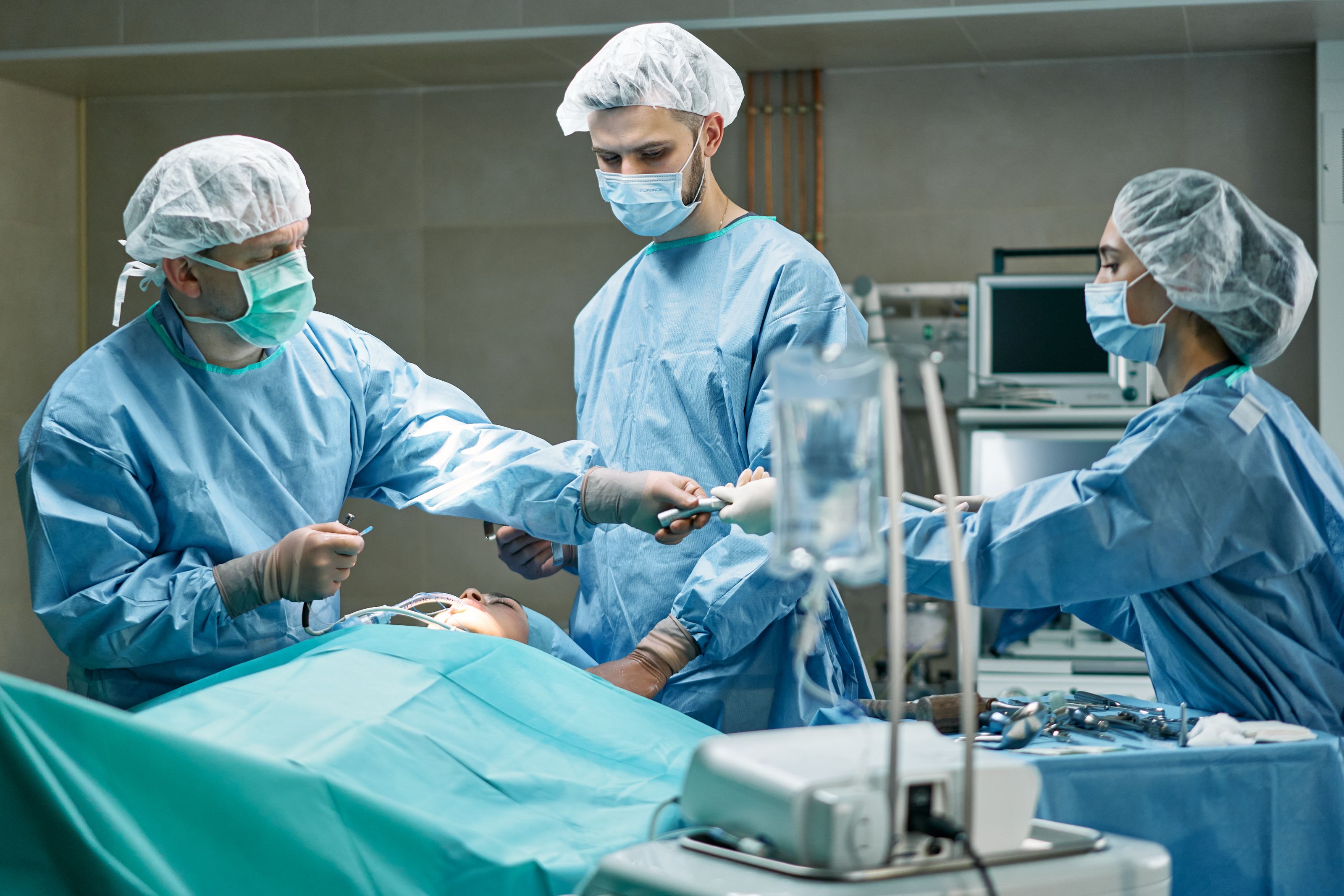 Medical team performing surgery in well-equipped operating room with focus.