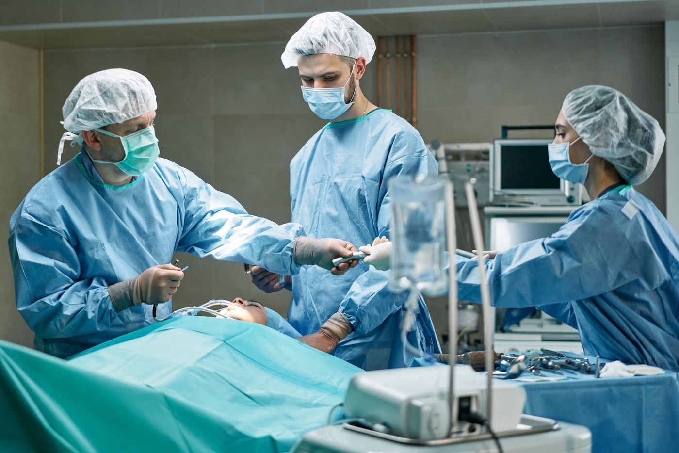 Medical team performing surgery in well-equipped operating room with focus.