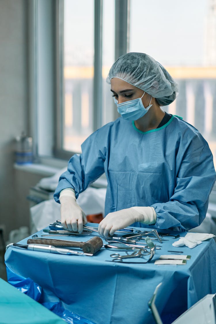 A Woman Arranging Medical Tools In An Operating Room