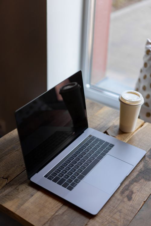 Silver Macbook on Wooden Table Beside a Paper Cup · Free Stock Photo