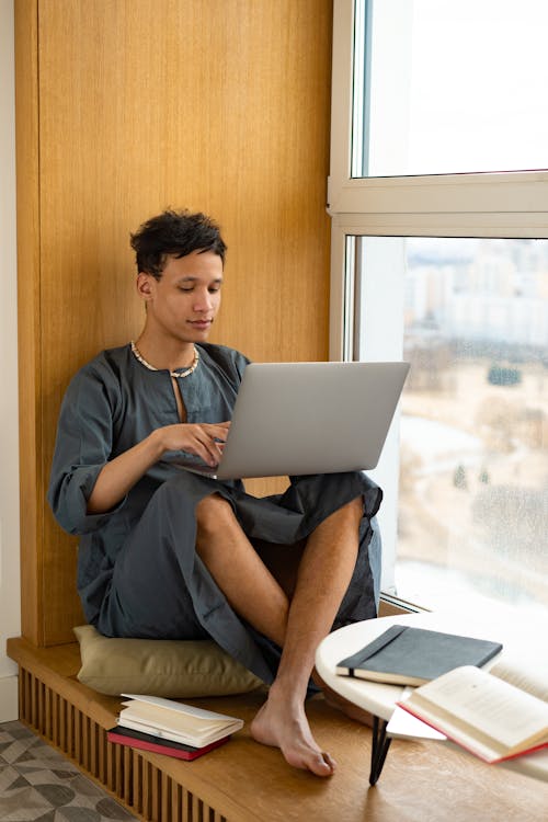 A Man Using a Laptop While Sitting