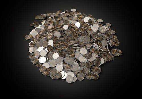 A high-angle shot of a pile of metallic cryptocurrency coins on a dark background.