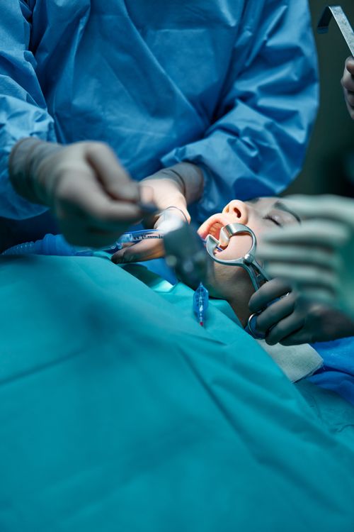 Free Close-up of a surgical team conducting an oral procedure in a sterile hospital environment. Stock Photo