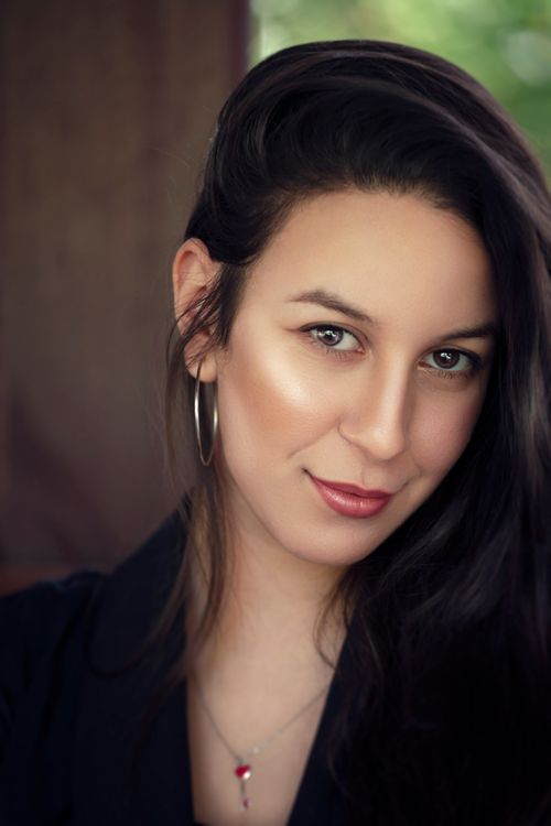 Free Close-up portrait of a smiling woman with long dark hair and hoop earring. Stock Photo