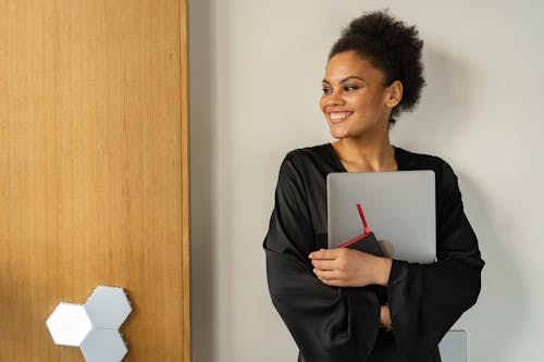 Free A Woman Smiling Holding Laptop Stock Photo