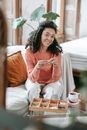 Woman in Orange Knit Sweater Sitting on Bed