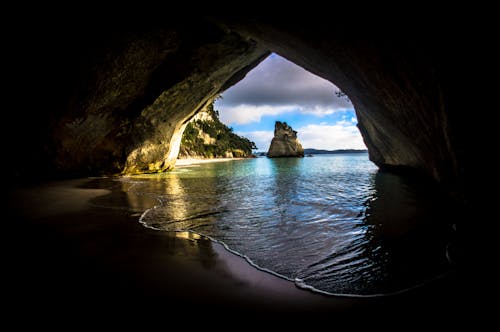 Ücretsiz Okyanusun Yakınındaki Gri Ve Kahverengi Mağara Stok Fotoğraflar
