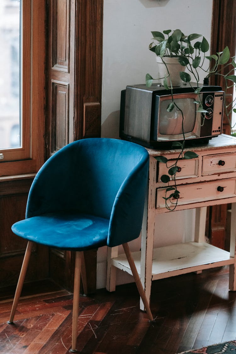 Cozy Chair Placed Near Shabby Cabinet With Retro TV