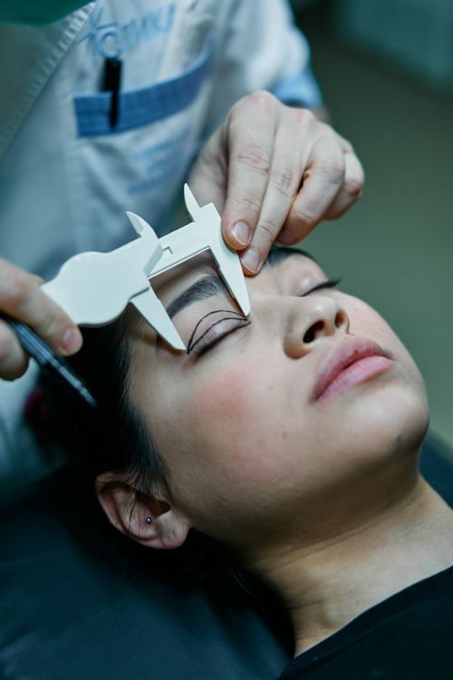 Free A surgeon measures a patient's eyelid for blepharoplasty preparations. Stock Photo