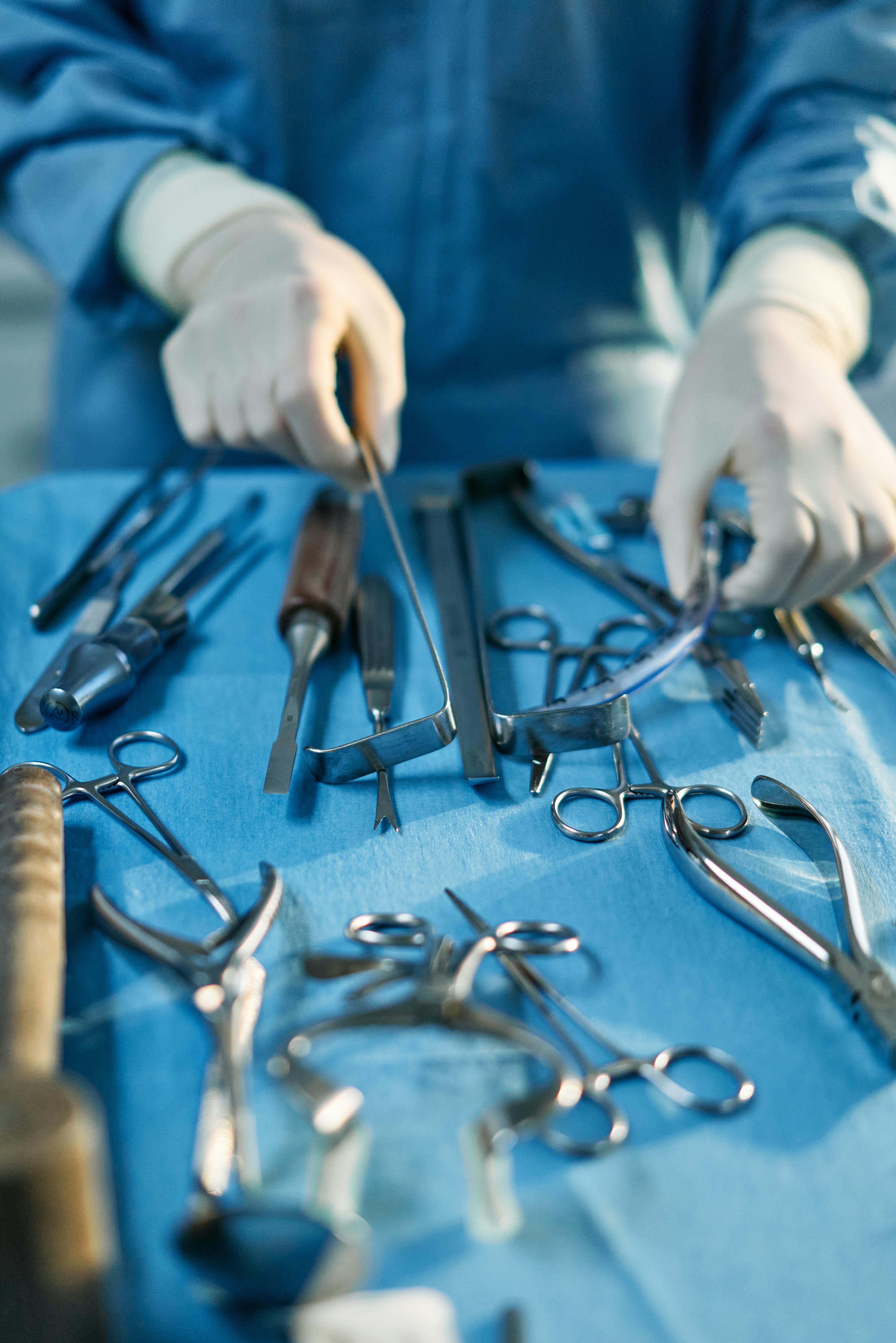 person holding silver medical tools