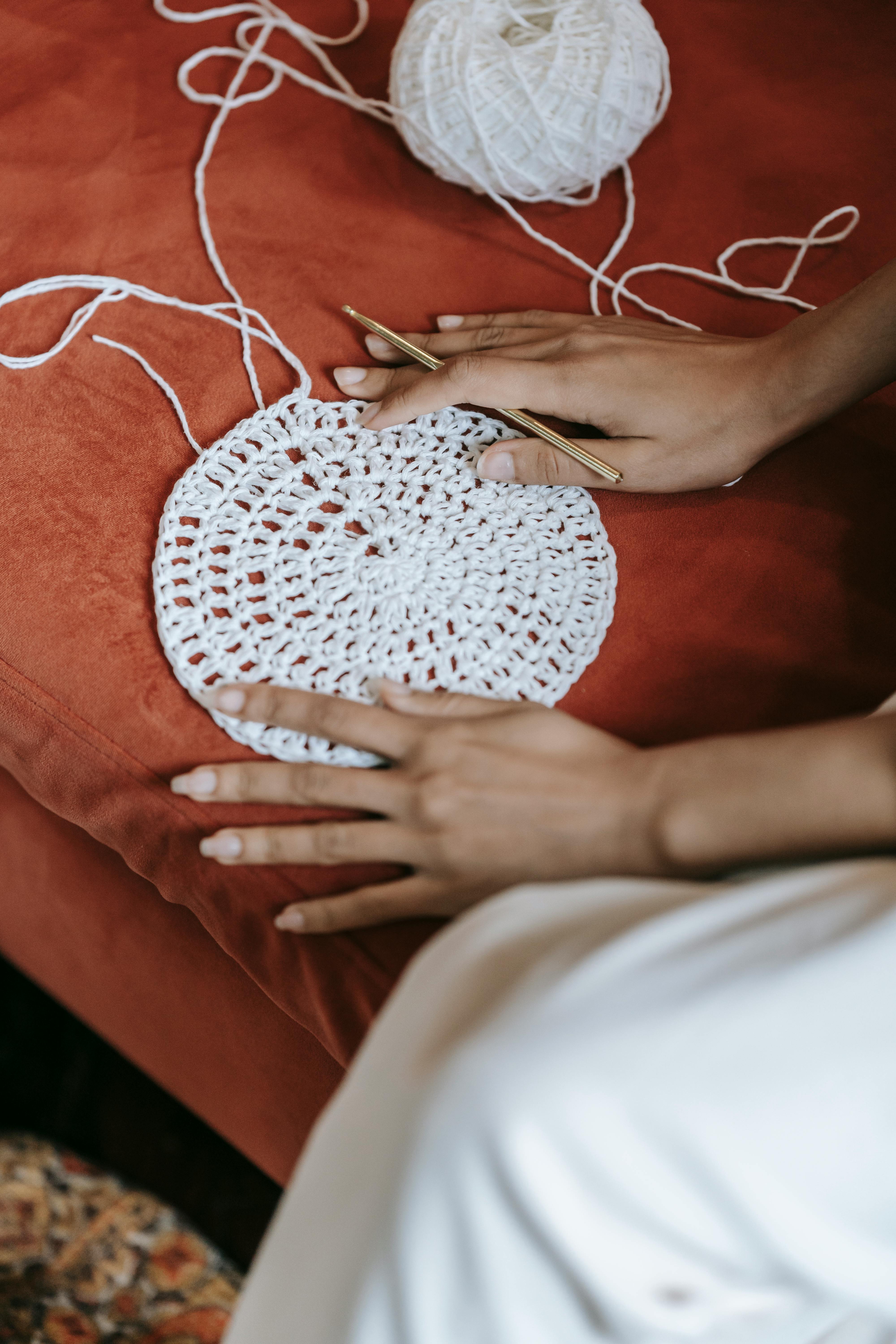 Hands crocheting with yarn and hook