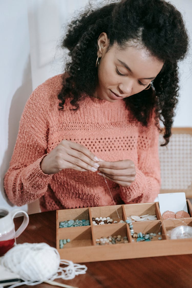 Focused Ethnic Woman Working With Different Beads