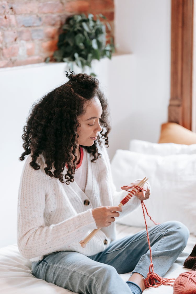 Black Woman Knitting On Bed