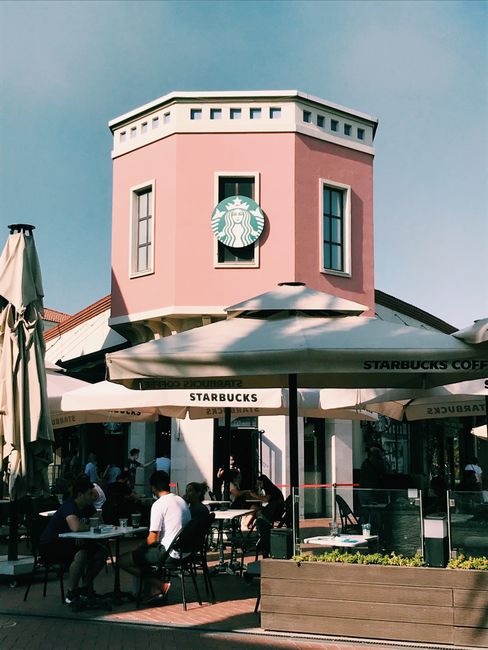 Al fresco dining at a pink Starbucks in Bornova, İzmir, Turkey. Lively outdoor café setting.