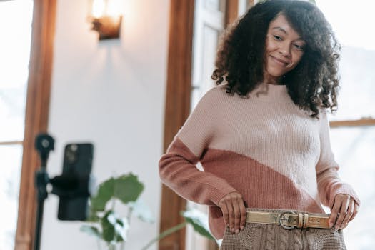 Smiling woman modeling a cozy knit sweater indoors, capturing a casual fashion moment.