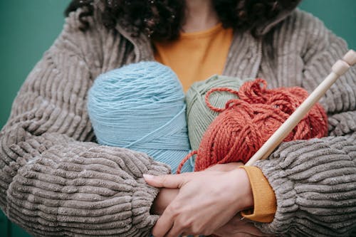Woman with skein of colorful yarn and knitting needles