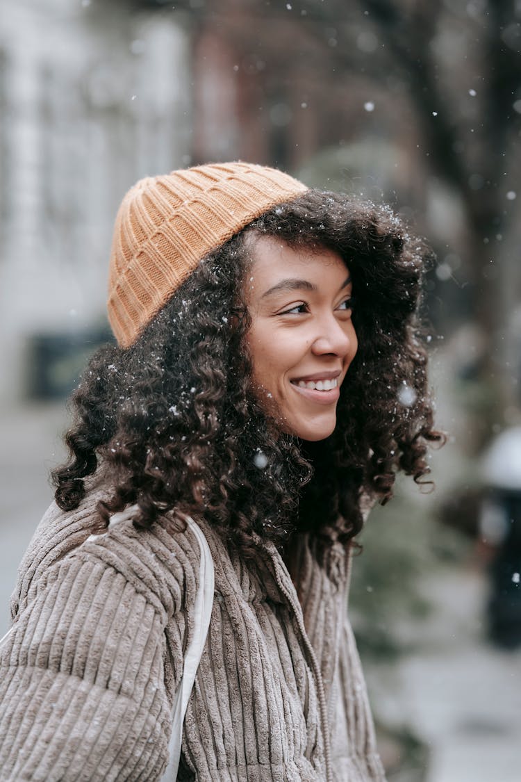 African American Young Woman In Warm Clothes Smiling On Street