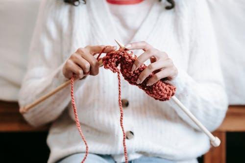 Faceless woman knitting with needles and yarn