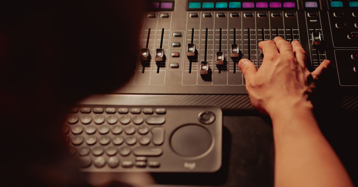 music producer working in recording studio with mixing board