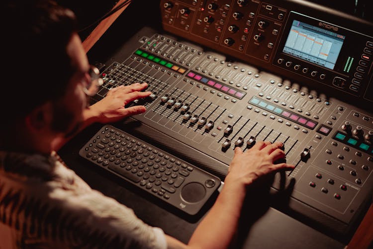 An Audio Engineer Controlling The Audio Mixer