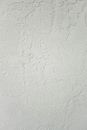 Minimalist clean background of white wall with roughness and cracks with scratches in studio in daylight
