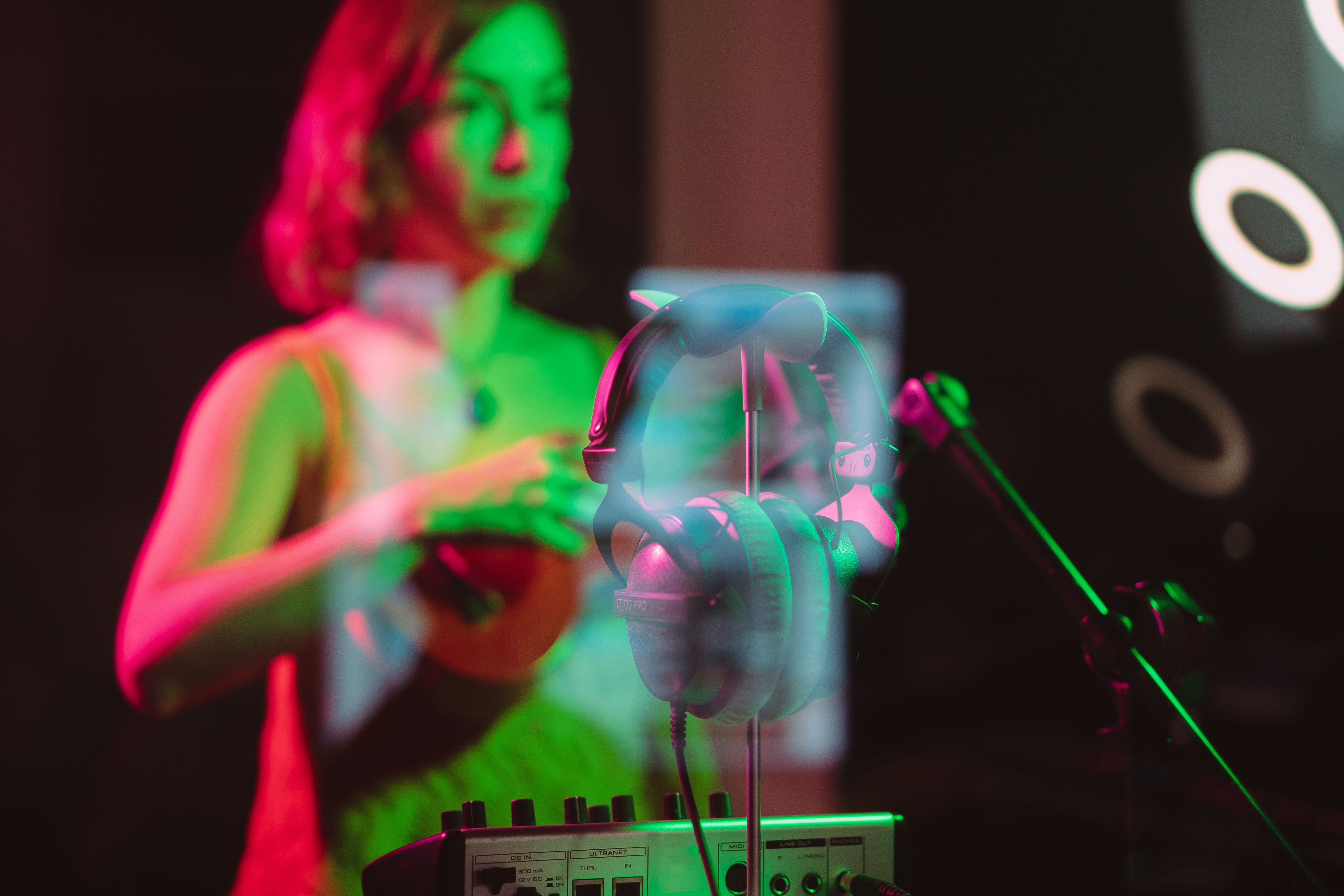 A futuristic recording studio with a glowing hologram of a music waveform and a human musician looking conflicted
