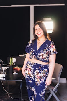 A woman in a floral outfit smiles confidently while posing in an indoor setting.