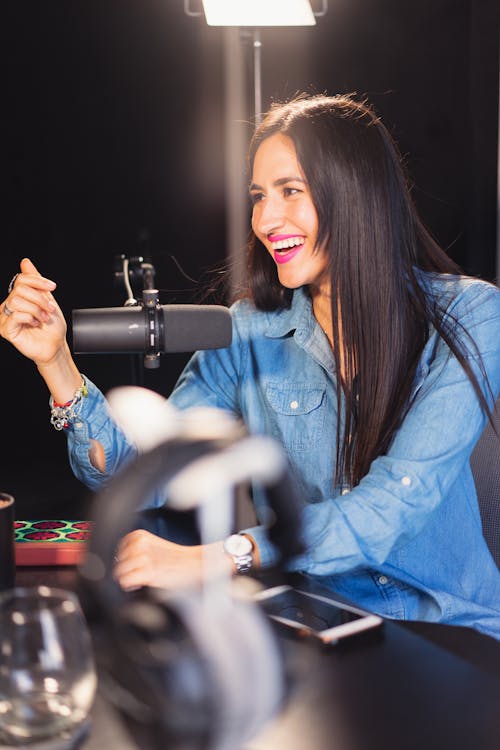 Free A Woman in Denim Clothes Talking in Front of the Microphone Stock Photo
