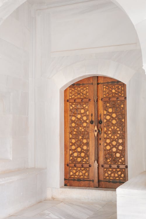 A Brown Wooden Door Near the White Wall
