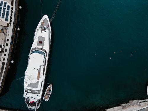 Free Stunning aerial shot of a luxury yacht moored in the vibrant blue waters of Il-Birgu, Malta. Stock Photo
