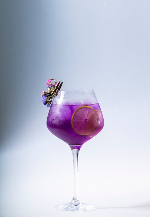 Free A Purple Liquid on a Clear Wine Glass with Sliced Lemon Stock Photo