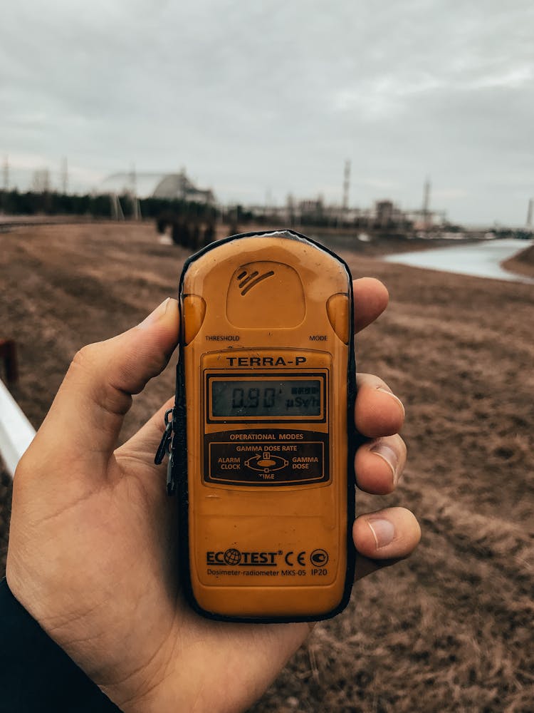 A Person Holding A Dosimeter