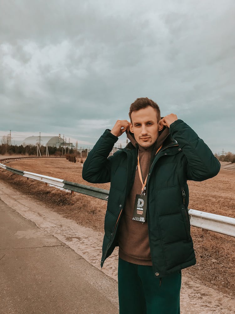 Photo Of A Man Putting On The Hood Of His Brown Hoodie