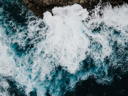 Free Stunning aerial shot of ocean waves crashing against the rocky shore in Il-Qrendi, Malta. Stock Photo