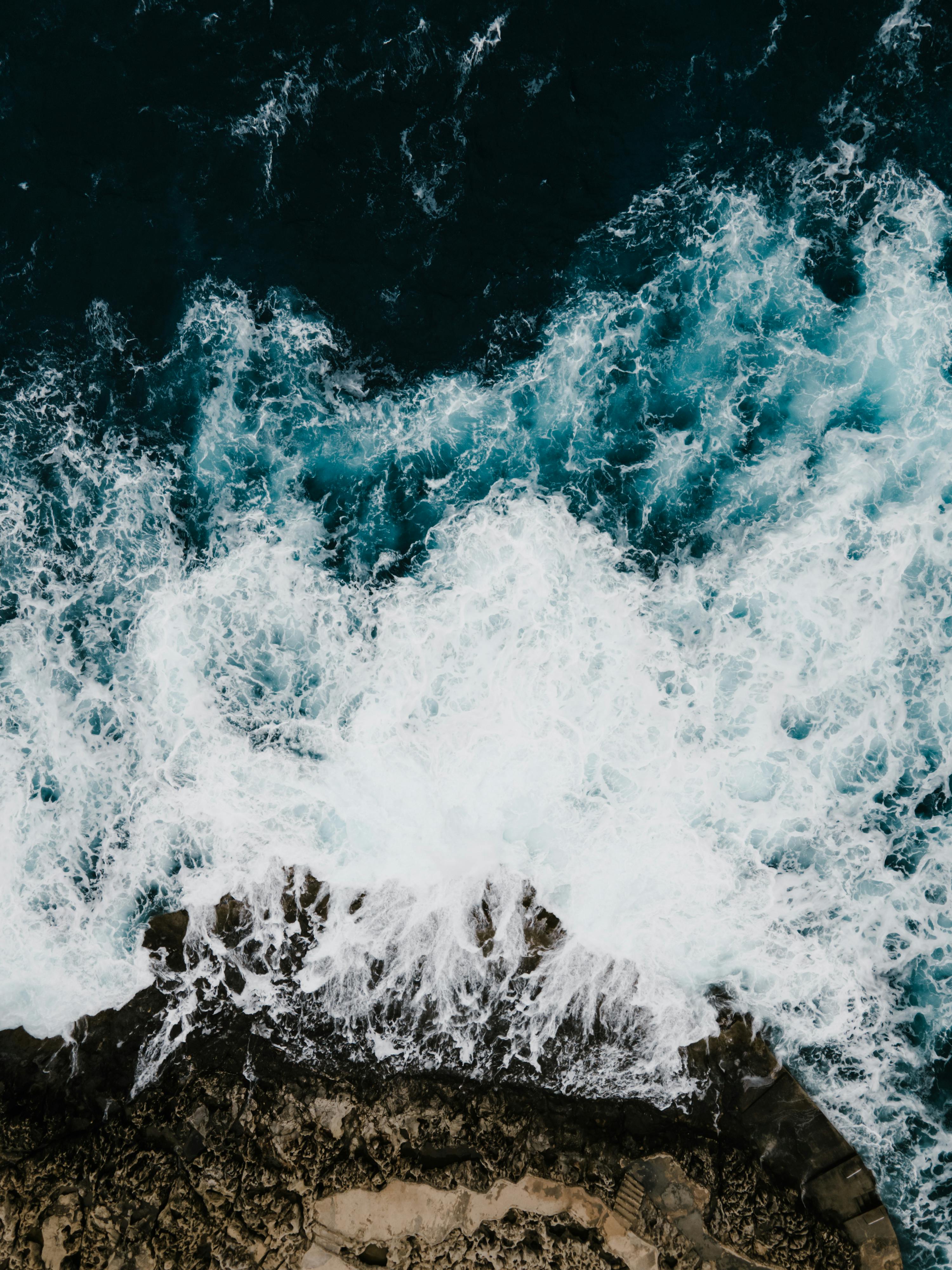 Stunning aerial shot capturing waves crashing on rocky shores in Il-Qrendi, Malta.