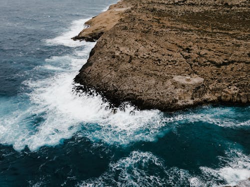 Brown Rock Formation Beside Body of Water