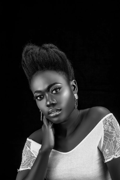Free Elegant black and white studio shot of a woman posing against a dark background. Stock Photo